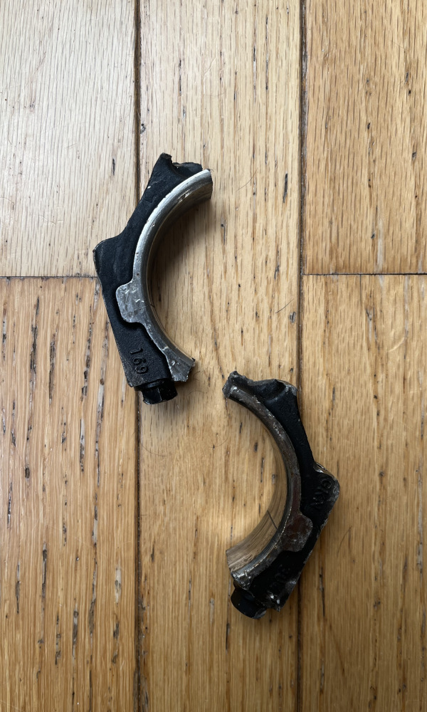 A connecting rod from a car broken in two.