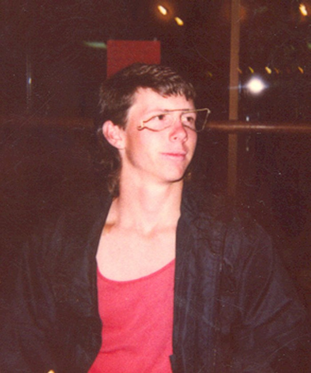 Young man wearing glasses with missing lenses and mangled frame.